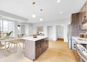 Thumbnail 86 of 92 - A modern kitchen with a dining table and chairs.