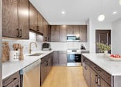 Thumbnail 76 of 92 - A modern kitchen with wooden cabinets and a white countertop.
