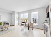 Thumbnail 108 of 110 - A modern living room with a grey couch and a wooden coffee table.