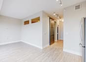 Thumbnail 29 of 64 - A spacious room with white walls and wooden flooring.