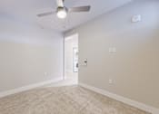 Thumbnail 30 of 64 - A room with a ceiling fan and carpeted floor.