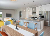 Thumbnail 23 of 64 - A modern kitchen with a wooden table and blue chairs.
