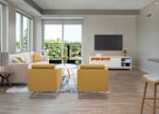 Thumbnail 25 of 64 - A living room with a white couch, yellow chairs, and a flat screen TV.