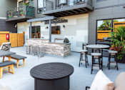 Thumbnail 43 of 64 - A patio area with a table, chairs, and a fireplace.