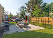 Thumbnail 51 of 64 - A black fence surrounds a picnic table in a park.