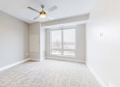 Thumbnail 22 of 64 - A room with a ceiling fan and a sliding glass door.