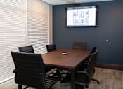 Thumbnail 12 of 81 - A conference room with a large screen and chairs.