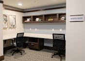 Thumbnail 14 of 81 - A business center with two chairs and a desk.