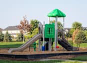 Thumbnail 21 of 81 - A playground with a green slide and a green umbrella.