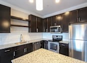 Thumbnail 40 of 81 - A kitchen with black cabinets and stainless steel appliances.