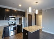 Thumbnail 41 of 81 - A kitchen with black cabinets and stainless steel appliances.