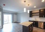 Thumbnail 42 of 81 - A kitchen with a granite countertop and wooden cabinets.