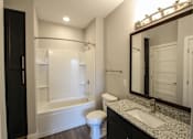 Thumbnail 44 of 81 - A white toilet sits in a bathroom next to a sink and a bathtub.