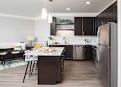 Thumbnail 45 of 81 - A modern kitchen with dark wood cabinets and a large island.