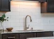 Thumbnail 49 of 81 - A kitchen with a sink and a counter.
