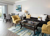 Thumbnail 50 of 81 - A living room with a grey couch, a yellow chair, and a coffee table.