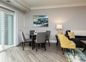 Thumbnail 51 of 81 - A modern living room with a grey sofa, a grey dining table and a yellow chair.