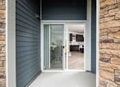 Thumbnail 52 of 81 - A glass door leads to a room with a dining table and chairs.
