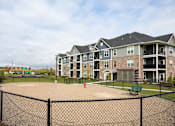 Thumbnail 63 of 81 - A large building with a fenced in playground in front.