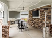 Thumbnail 76 of 81 - A patio with a table and chairs and a brick wall.
