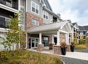 Thumbnail 79 of 81 - A modern building with a grey and white exterior and a covered walkway.