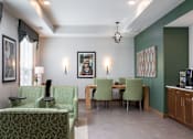Thumbnail 25 of 32 - A living room with a green couch and a dining table with chairs.at The Edison at Rice Creek I and II, Shoreview
