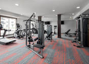 Thumbnail 14 of 24 - A gym with a variety of equipment including treadmills, weights, and exercise machines at The Edison at Woodbury, Woodbury