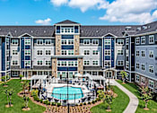 Thumbnail 75 of 80 - A large apartment complex with a pool in the middle of the courtyard at The Barnum Apartments, Minnesota