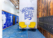Thumbnail 20 of 20 - Two yellow chairs are placed in front of a wall with the words "Historic Lee Lofts" written on it.
