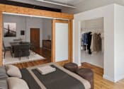 Thumbnail 3 of 20 - A bedroom with a bed, a chair, and a ceiling fan.