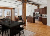 Thumbnail 2 of 20 - A modern kitchen with wooden floors and a dining table with chairs.