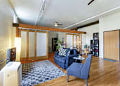 Thumbnail 11 of 20 - A living room with a blue couch and a grey rug.
