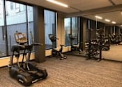 Thumbnail 6 of 47 - A gym with treadmills, elliptical machines, and other exercise equipment at The Redwell Apartments, Minneapolis