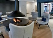 Thumbnail 11 of 47 - A modern living room with a fireplace and chairs at The Redwell Apartments, Minneapolis, Minnesota