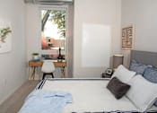 Thumbnail 24 of 47 - A bedroom with a bed, desk, and chair at The Redwell Apartments, Minneapolis, MN 55401