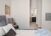 Thumbnail 28 of 47 - A bedroom with a bed, nightstand, and a mirror in the hallway at The Redwell Apartments, Minneapolis, 55401