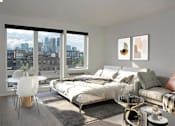Thumbnail 29 of 47 - A bedroom with a large bed and a view of the city at The Redwell Apartments, Minnesota 55401