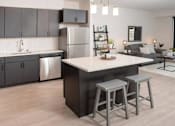 Thumbnail 33 of 47 - A kitchen with a bar stool in front of it at The Redwell Apartments, Minnesota