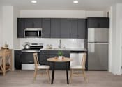 Thumbnail 39 of 47 - A modern kitchen with a table and chairs. at The Redwell Apartments, Minnesota