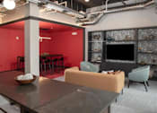 Thumbnail 43 of 47 - A modern living room with a grey sofa and a black television at The Redwell Apartments, Minneapolis, MN 55401