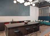 Thumbnail 44 of 47 - A modern kitchen with a bar area and a dining area in the background at The Redwell Apartments, Minneapolis, MN