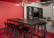 Thumbnail 45 of 47 - A modern dining area with a dark table and chairs at The Redwell Apartments, Minneapolis, 55401