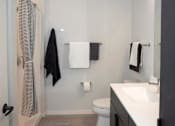 Thumbnail 47 of 47 - A bathroom with a toilet, sink, and towel rack at The Redwell Apartments, Minneapolis