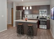 Thumbnail 12 of 54 - A modern kitchen with a center island and stools.