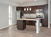 Thumbnail 18 of 54 - A modern kitchen with a center island and dark wood cabinets.