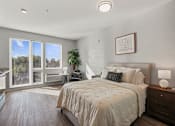 Thumbnail 1 of 54 - A bedroom with a large bed and a view of the outdoors through the sliding glass doors.