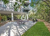 Thumbnail 47 of 54 - A patio with a table and chairs is surrounded by trees.