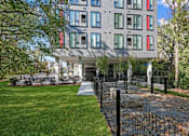 Thumbnail 50 of 54 - A modern building with a black fence in front.