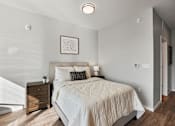 Thumbnail 6 of 54 - A bedroom with a bed, nightstand, and a window with blinds.
