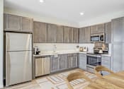 Thumbnail 9 of 36 - A Kitchen with a Refrigerator at Peregrine Apartments, Minneapolis, MN, 55411